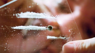 Person konsumiert Kokain mit einem Röhrchen Person konsumiert Kokain mit einem Röhrchen