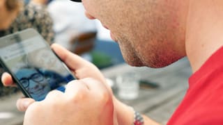 Ein sehbehinderter Mann tippt auf dem Smartphone. Ein sehbehinderter Mann tippt auf dem Smartphone.