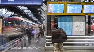 Ein Mann betrachtet am Bahnhof Zürich den Bildschirm mit den Zugsabfahrten