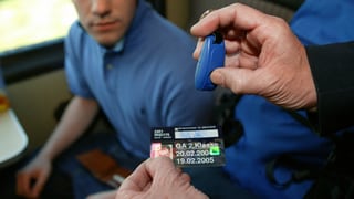 Ein Kondukteur kontrolliert im Zug ein GA. Ein Kondukteur kontrolliert im Zug ein GA.