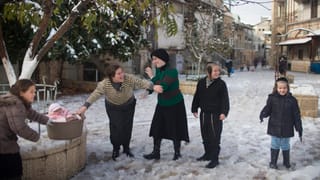 Frauen und Kinder stehen im Schnee und lachen. Frauen und Kinder stehen im Schnee und lachen.