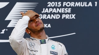 Lewis Hamilton blickt während der Siegerehrung ehrfürchtig gen Himmel.