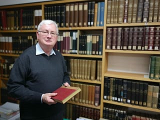 Mann vor einer Bücherwand. Mann vor einer Bücherwand.