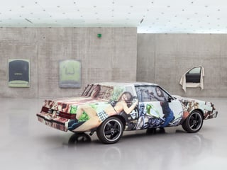 Ein Auto mit Fotos von Frauen auf der Karrosserie.