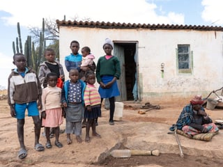 Die Bäuerin Loice Muchachati mit Kindern vor ihrem Haus. 
