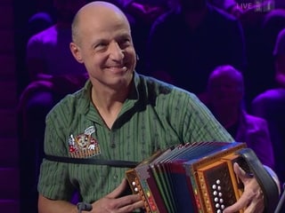 Mann spielt Schwyzerörgeli während Konzert. Mann spielt Schwyzerörgeli während Konzert.