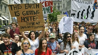 Eine Gruppe junger Erwachsener mit Portestschildern. Eine Gruppe junger Erwachsener mit Portestschildern.