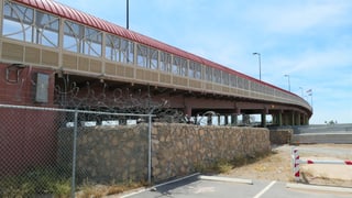 Brücke über eine Grenze und Stahlzaun.