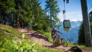 Drei Biker fahren den Bike Trail in den Flumserbergen hinunter. Drei Biker fahren den Bike Trail in den Flumserbergen hinunter.