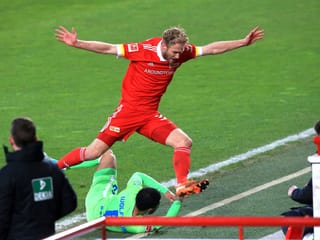 Zweikampf zwischen Otavio und Griesbeck. Am Bildrand Staffmitglieder der beiden Teams.