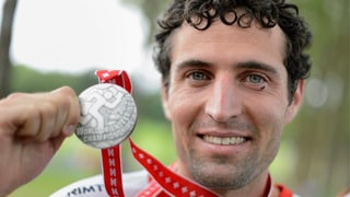 Matthias Merz zeigt seine Silbermedaille in die Kamera