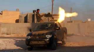 Ein Kämpfer feuert ein Geschütz auf einem Fahrzeug ab.