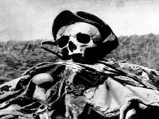 Skelett in Soldatenkleidung auf einem leeren Feld.