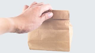 Ein Mann hält eine Papiertüte in der Hand