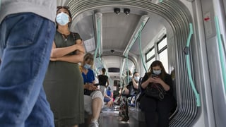 Menschen in einem Tram mit Maske.