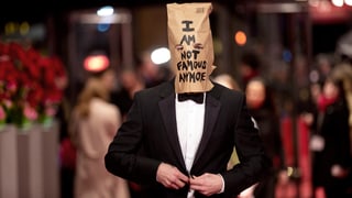 ShiaLaBeouf trägt einen Anzug und einen Karton auf dem Kopf mit der Aufschrift: «I am not famous anymore».