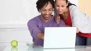Ein junges Paar vor dem Laptop