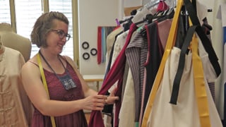 Junge Frau vor Kleiderständer Junge Frau vor Kleiderständer