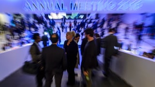 Menschen auf einer Rampe unter einer bläulichen Leuchtschrift «Annual Meeting 2016».