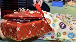 Ein Verkäuferin in einem Spielwarengeschäft packt Geschenke ein.