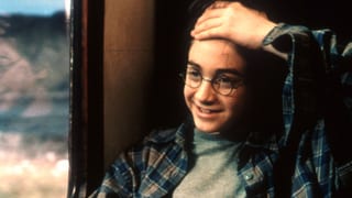 Harry Potter mit Narbe auf der Stirn sitzt in einem Zug und streicht die Fransen zurück. Harry Potter mit Narbe auf der Stirn sitzt in einem Zug und streicht die Fransen zurück.
