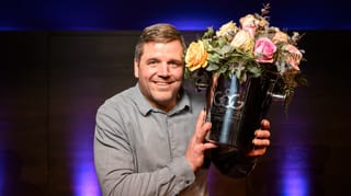 Mann in grauem Hemd mit Blumenstrauss in der linken Hand Mann in grauem Hemd mit Blumenstrauss in der linken Hand