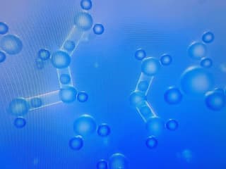 Schamatisch sublimierender Wasserdampf, ein blauer Hintergrund darauf Moleküle die sich verbinden (kleine blaue Kugeln).