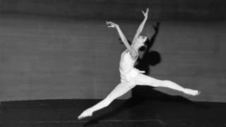 Eine springende Ballerina auf einem schwarz-weiss-Bild.