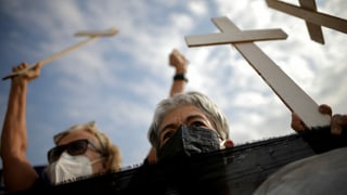 Demonstrierende mit weissen Kreuzen.