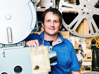 Raff Fluri steht zwischen alten Filmprojektoren und -rollen. Raff Fluri steht zwischen alten Filmprojektoren und -rollen.
