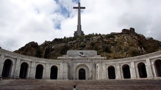 Eine Person auf dem grossen Platz vor dem Mausoleum mit Kreuz.