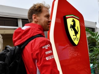 Sebastian Vettel vor einem Ferrari-Logo