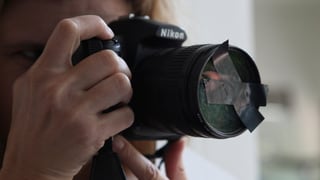 Ein Fotograf hat eine Linse vor dem Fotoapparat abgeklebt. Ein Fotograf hat eine Linse vor dem Fotoapparat abgeklebt.