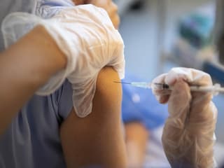 Impfstoff wird in einen Oberarm gespritzt