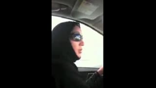 Manal al Sharif mit KOpftuch und Sonnenbrillen am Steuer.
