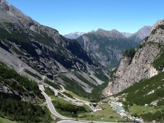 In einem klaren Bergsee spiegelt sich die Gebirgskulisse.