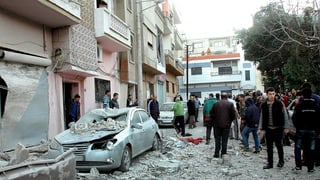 Einwohner von Homs besichtigen Schäden an Fassaden und Fahrzeugen