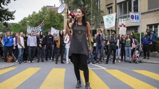 Eine Frau steht mit Megafon auf der Strasse. Eine Frau steht mit Megafon auf der Strasse.