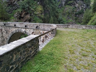 Eine alte Steinbogenbrücke über einen Fluss.