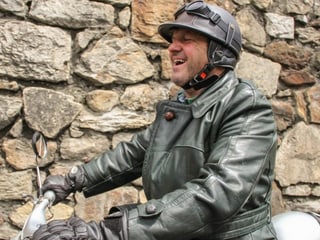 Mann mit Helm auf Moped