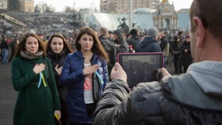 Drei junge Frauen lassen sich auf dem inzwischen friedlichen Maidanplatz fotografieren. 