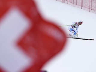 Die Schweizer Flagge verdeckt einen Skifahrer.