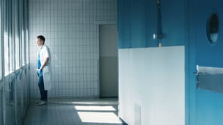 Ein Arzt in der Klinik: er schaut nachdenklich aus dem Fenster. Ein Arzt in der Klinik: er schaut nachdenklich aus dem Fenster.