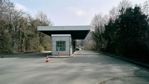 Verlassenes Grenzkontrollgebäude mit Verkehrskegel auf der Strasse.