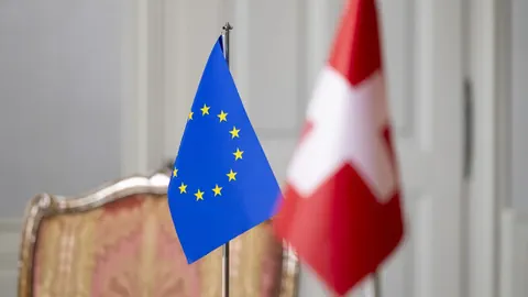 EU- und schweizerische Flaggen im Raum.