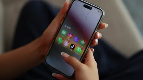 Symbolbild: Ein Smartphone in einer Hand einer Jugendlichen.