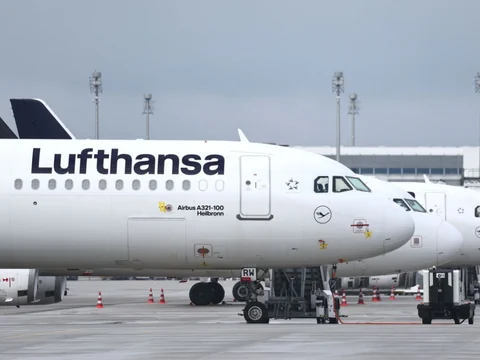 Mehrere weisse Flugzeuge der deutschen Fluggesellschaft stehen am Flughafen München in Reih' und Glied'.