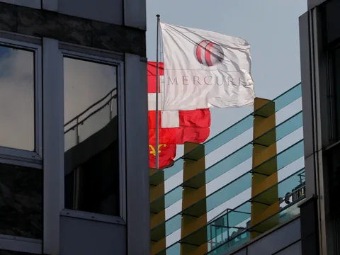 Weisse Flagge mit Logo, neben roten Flaggen auf Bürogebäude.