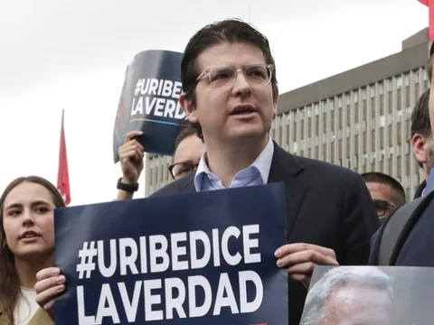 Personen halten Schilder mit '#URIBEDICELAVERDAD'.