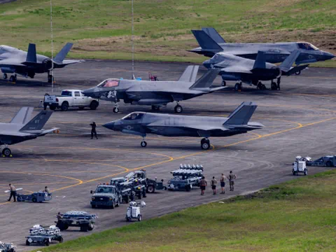 Kampfjets auf einem Flugplatz mit Militärpersonal und Fahrzeugen.